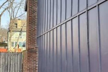A purple wall enclosed by a wooden fence.